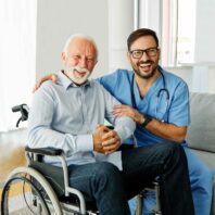 Soins infirmiers Humensia – infirmier sourirant avec patient en fauteuil